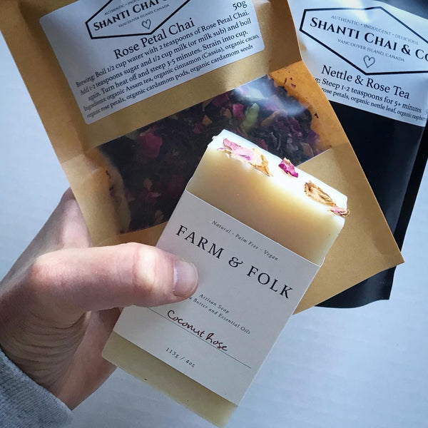 A hand holds Shanti Chai & Co's "All Rose" Gift Set of Rose Petal Chai, Nettle & Rose Tea and Coconut Rose soap from Farm & Folk.